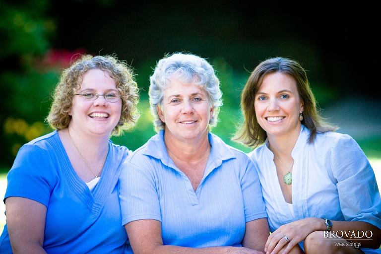 three women in blue tops pose together