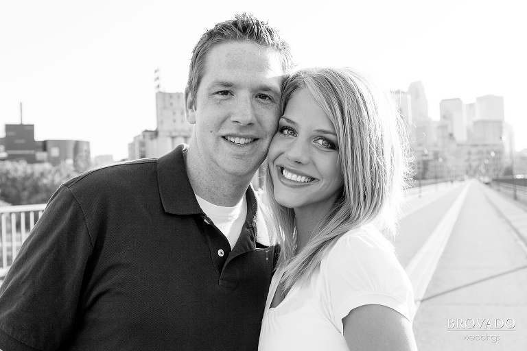 black and white engagement photo of a smiling couple on the minneapolis stone arch bridge