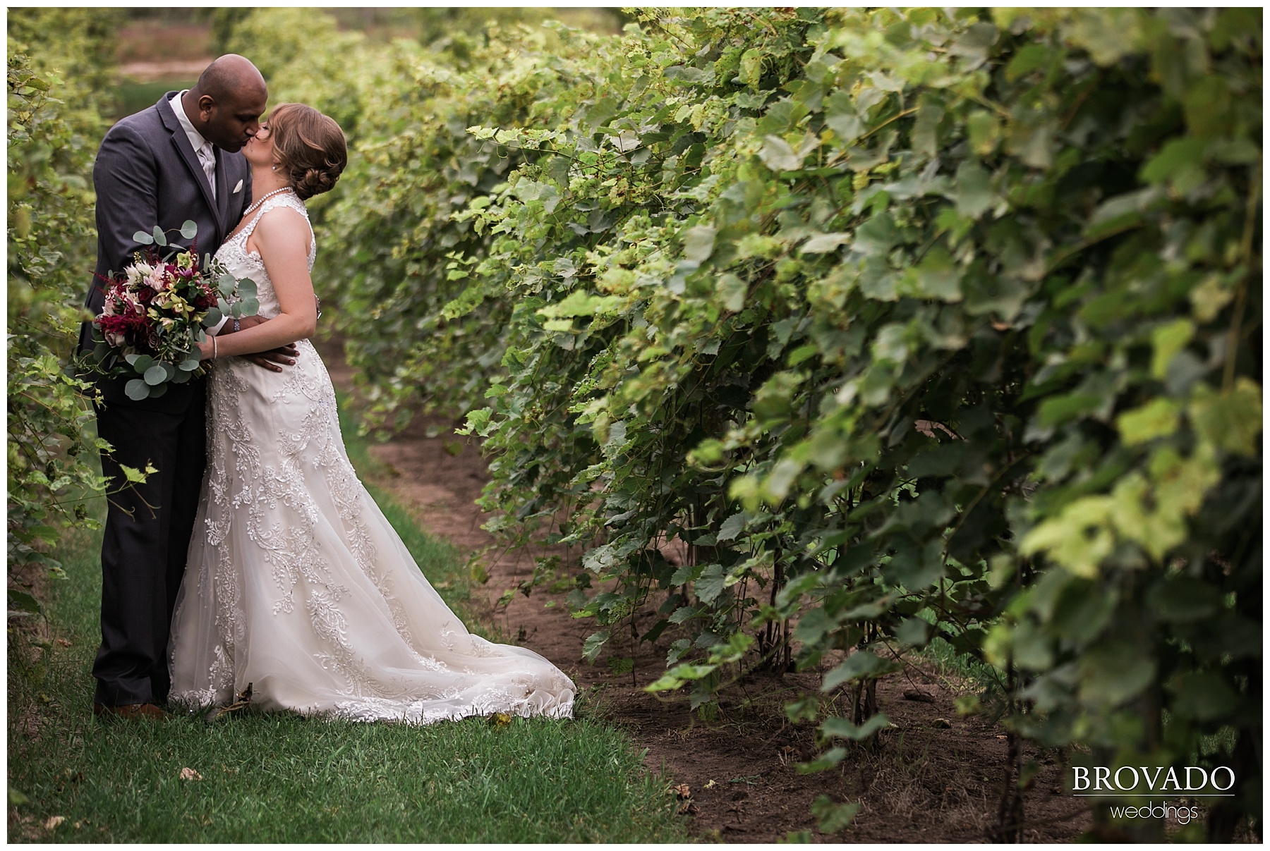 bride and groom pose in vineyard on wedding day