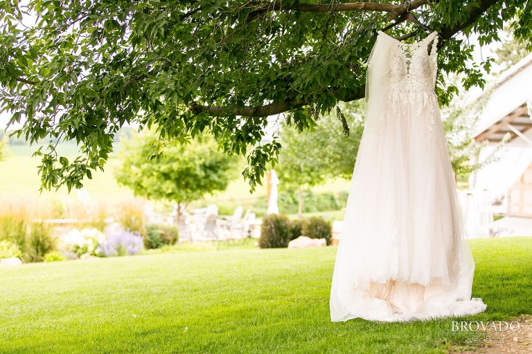 Heather's wedding dress and veil hanging from a tree